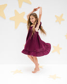girl model showing the left side of the river dress in aubergine muslin cotton
