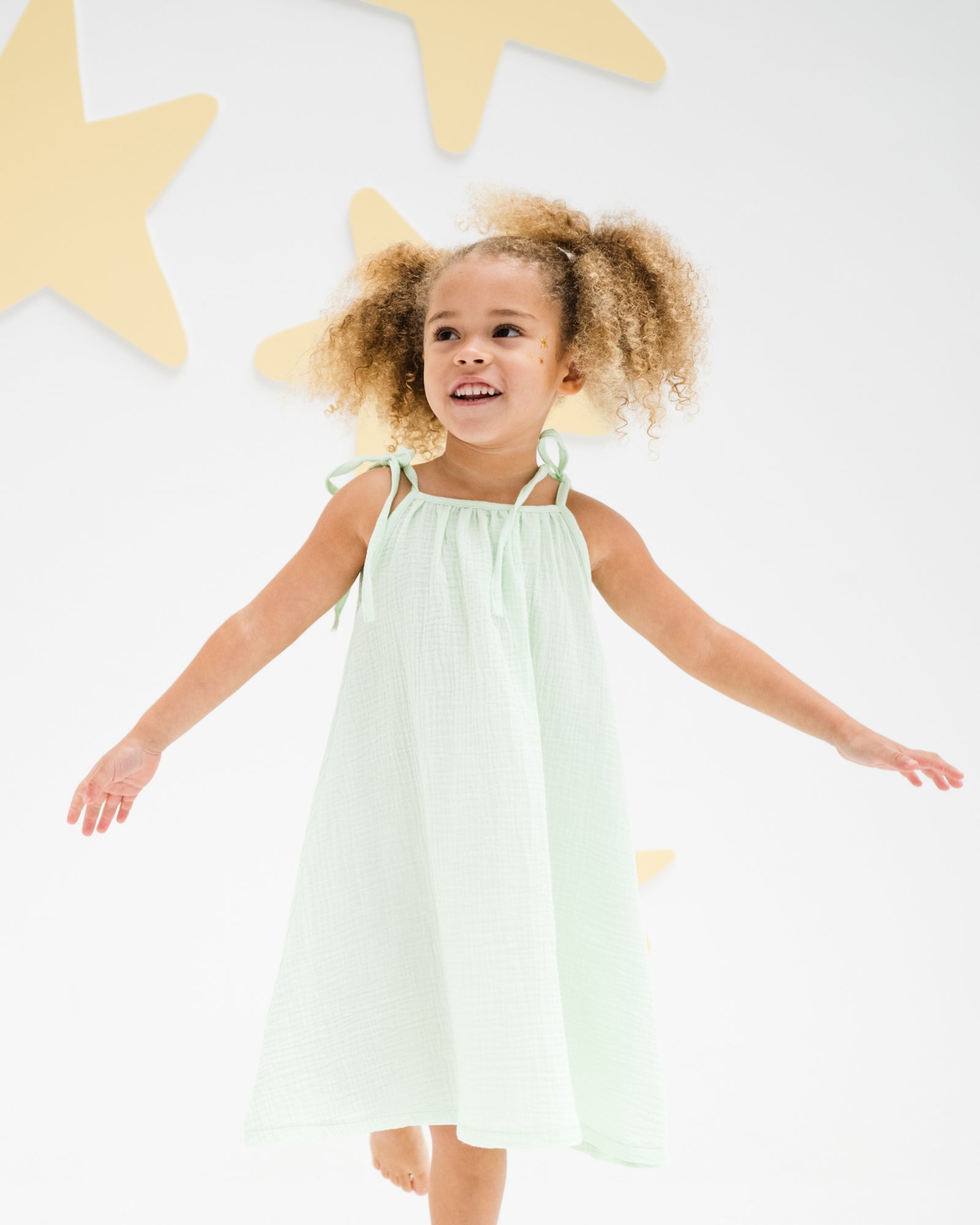 girl model wearing the romy dress in soft mint muslin cotton