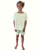 boy model wearing this comfy muslin set in mint, the cameron top has a boat neck and has an oversized look