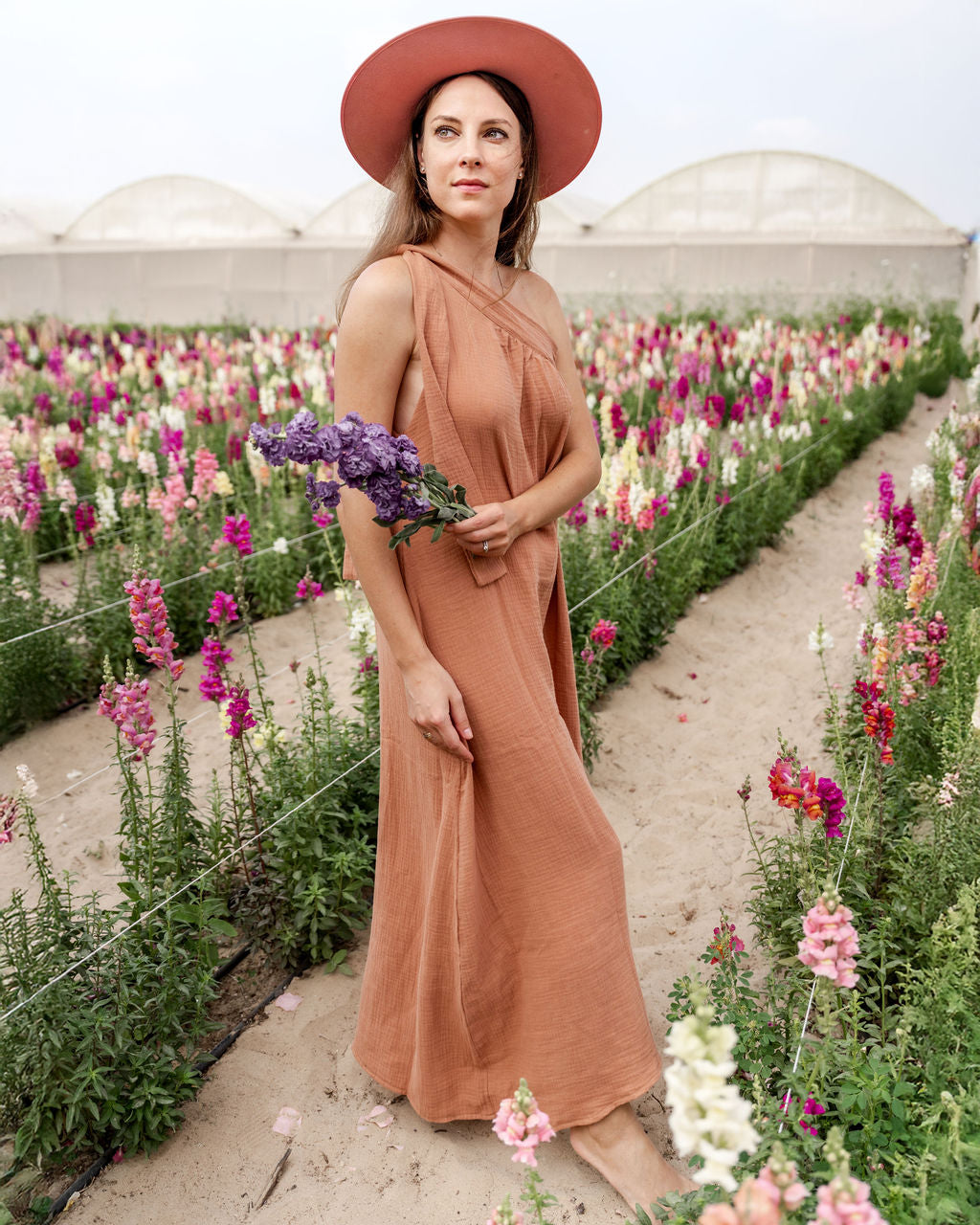 model wearing the assymetric Olympia dress in caramel muslin cotton